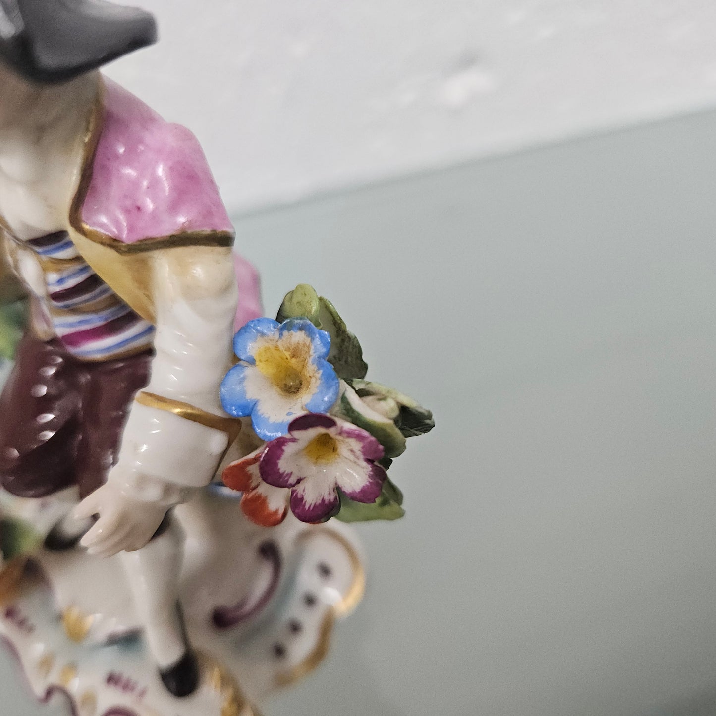 Stunning detailed early figure of a boy with flowers, there is a gold anchor mark to the back of the statue. It is in good original condition with some missing parts on the flowers as