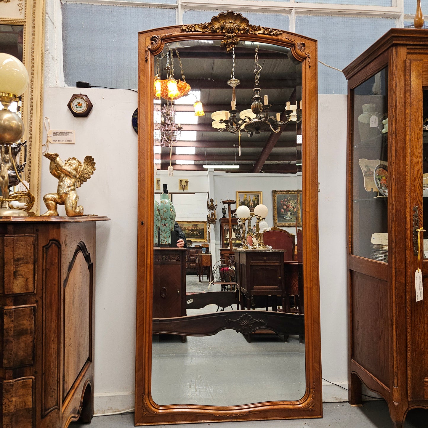 A fabulous tall Louis XV style Walnut floor/mantle mirror featuring decorative bronze gilt ormolu mounts. It still contains its beautiful original bevelled edged mirror. It has been sourced from France and is in good original detailed condition.