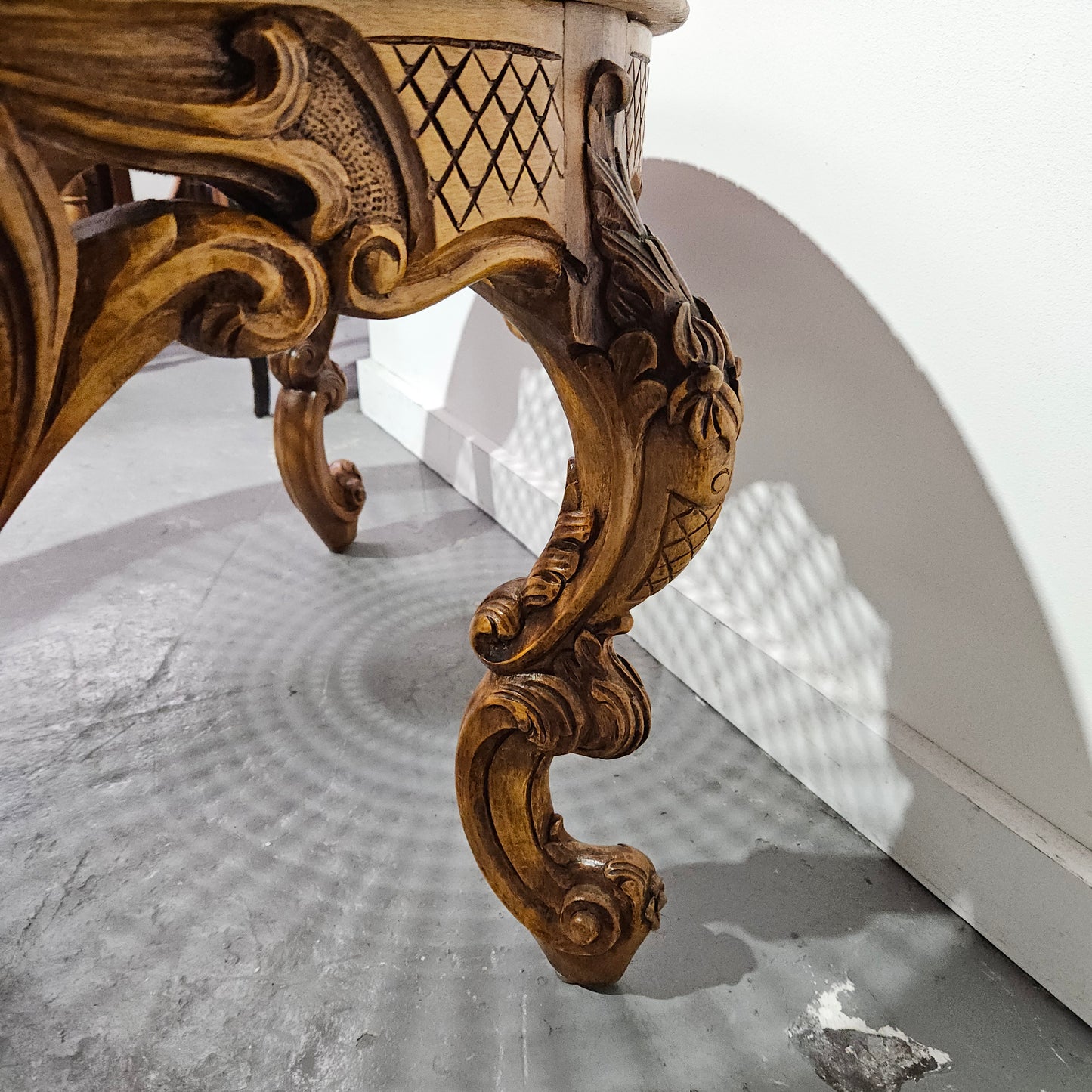 French oak Louis XV style round cane insert coffee table with highly decorative legs and table top. It has a glass cover to fit over the cane. It is in good original condition and has been sourced from France.