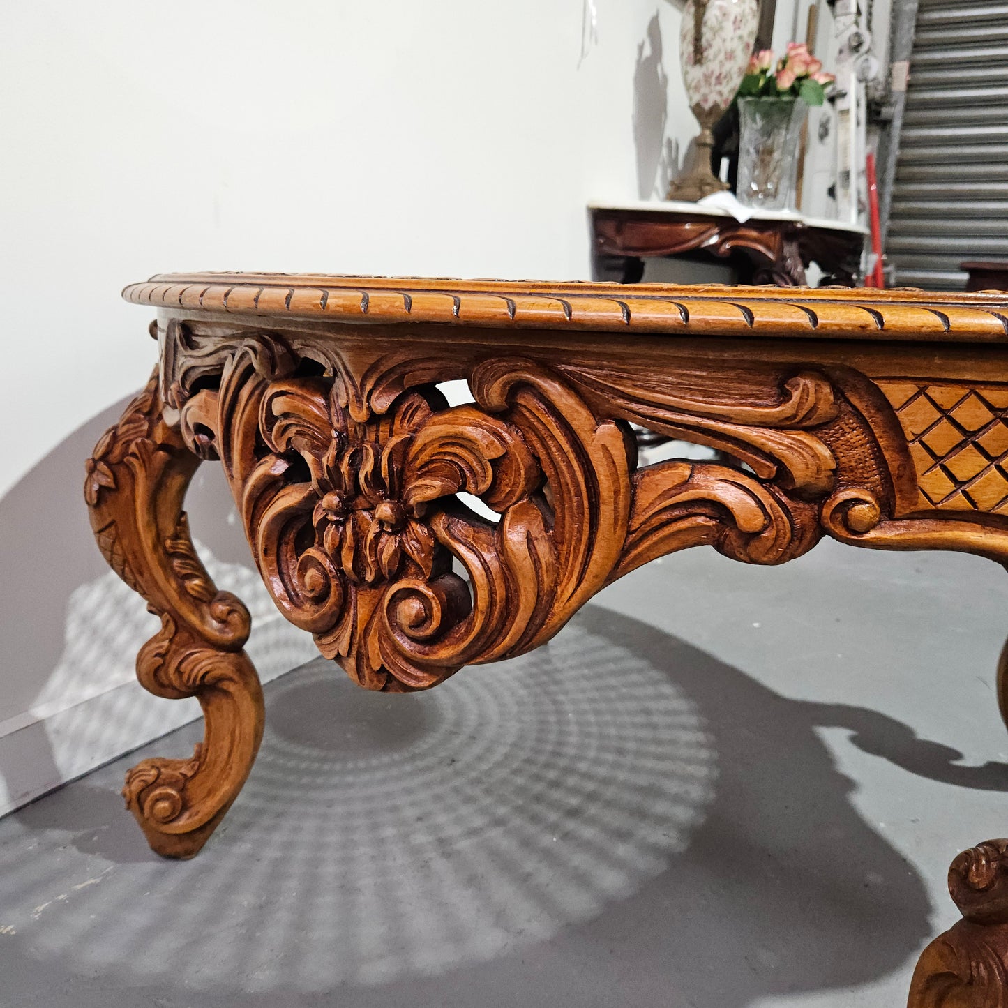 French oak Louis XV style round cane insert coffee table with highly decorative legs and table top. It has a glass cover to fit over the cane. It is in good original condition and has been sourced from France.