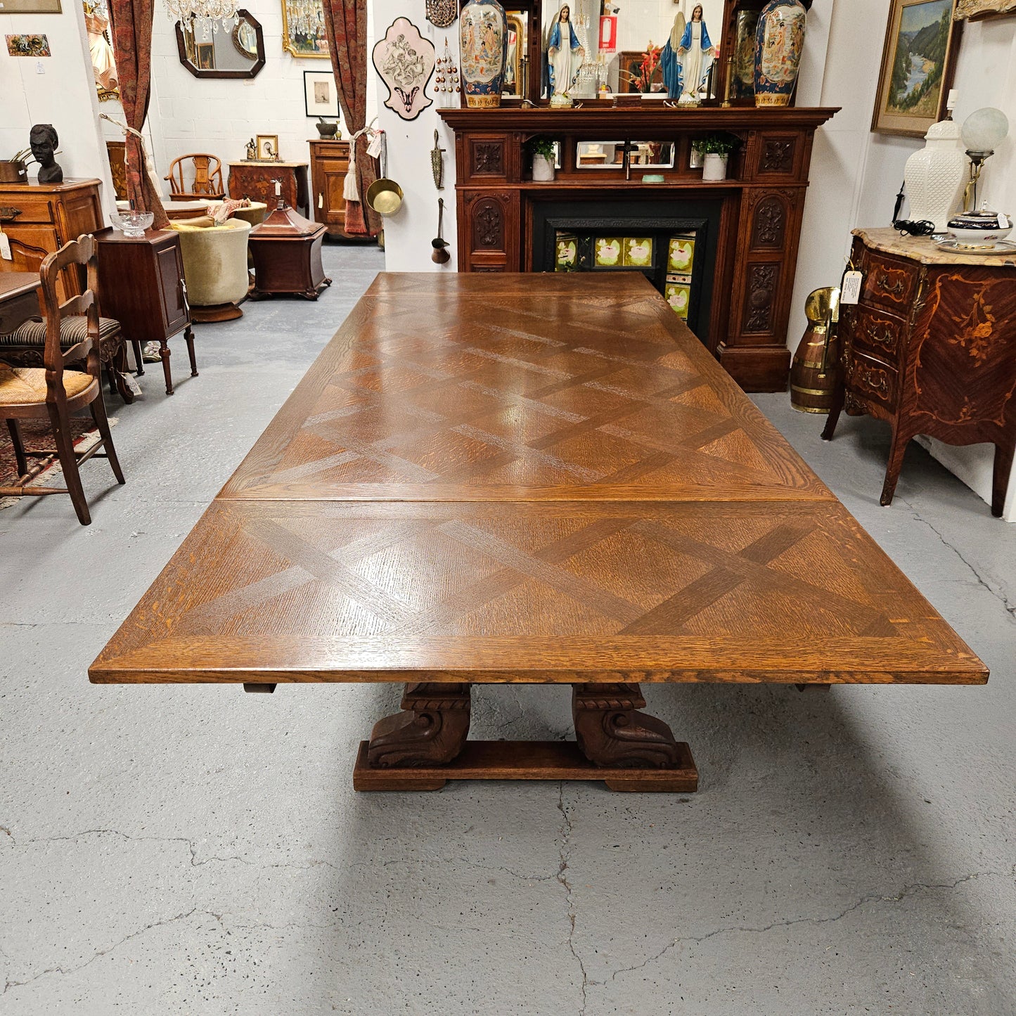 Beautiful French Oak Spanish style extension dining table with a decorative iron base and parquetry top. Lovely carvings on the legs and the skirt of the base. With the extensions closed it is 179.5 cm long and when fully extended it is 279 cm long.