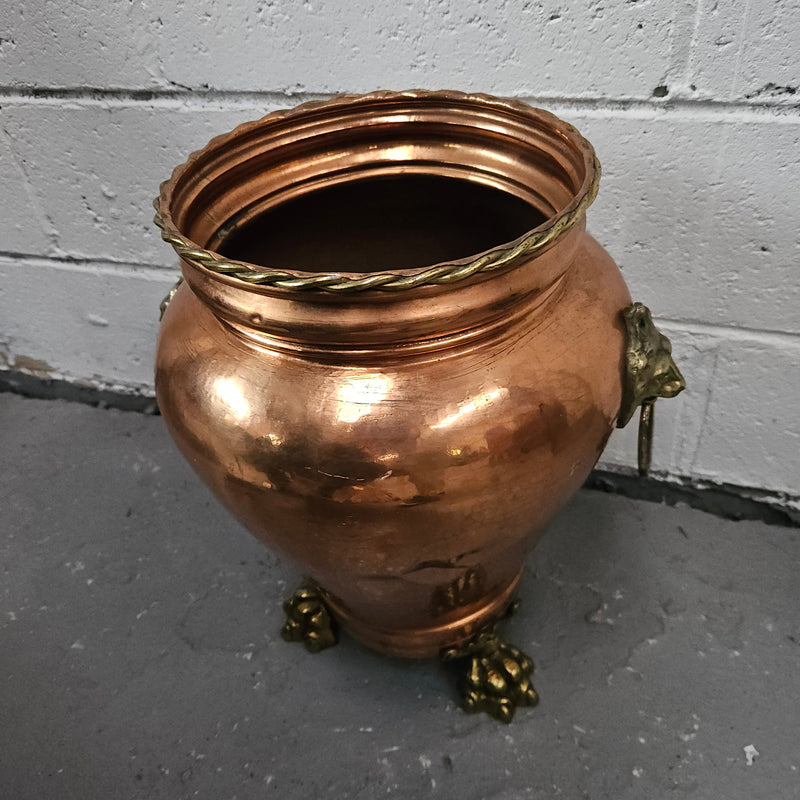 Lovely copper and brass pot with lions heads on the handles and lions feet on the base. It is in good original condition.