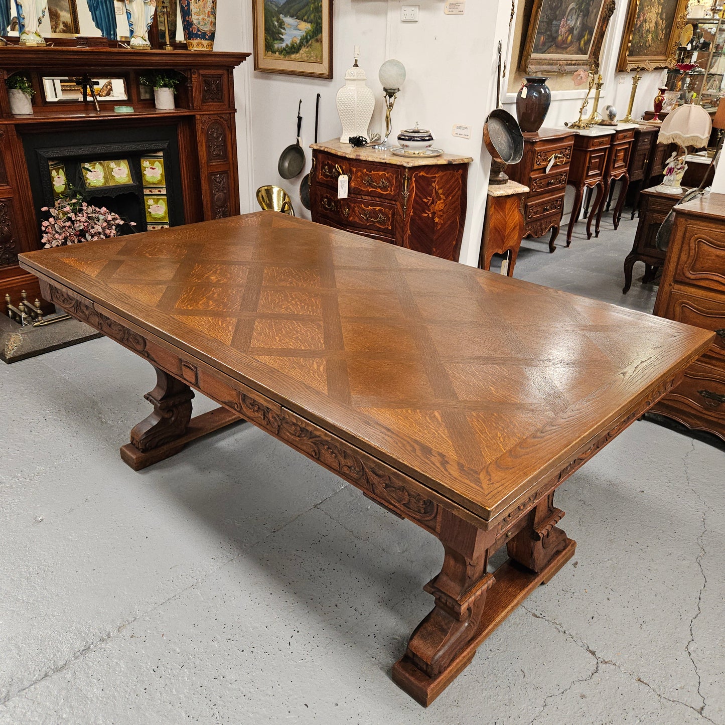 Beautiful French Oak Spanish style extension dining table with a decorative iron base and parquetry top. Lovely carvings on the legs and the skirt of the base. With the extensions closed it is 179.5 cm long and when fully extended it is 279 cm long.