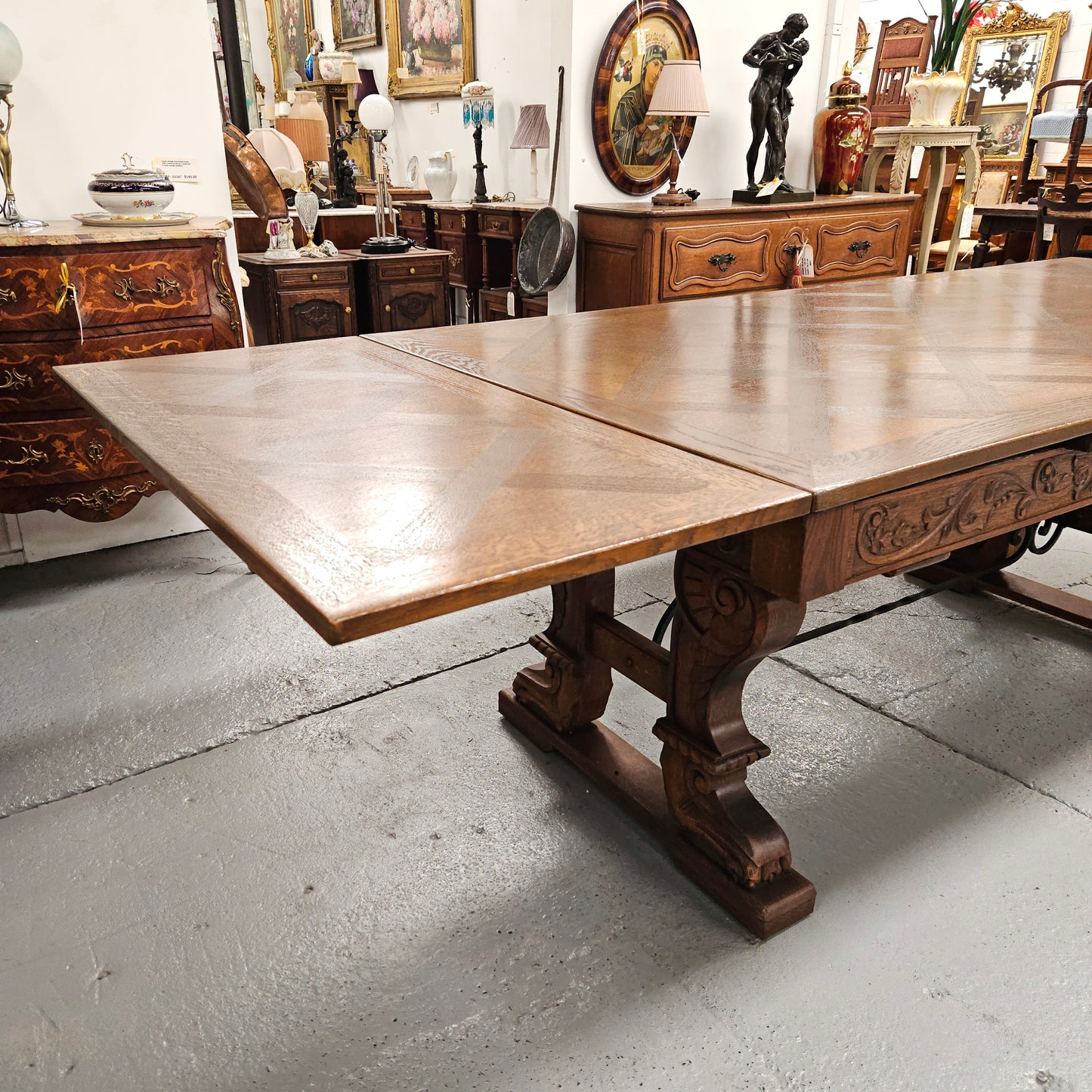 Beautiful French Oak Spanish style extension dining table with a decorative iron base and parquetry top. Lovely carvings on the legs and the skirt of the base. With the extensions closed it is 179.5 cm long and when fully extended it is 279 cm long.