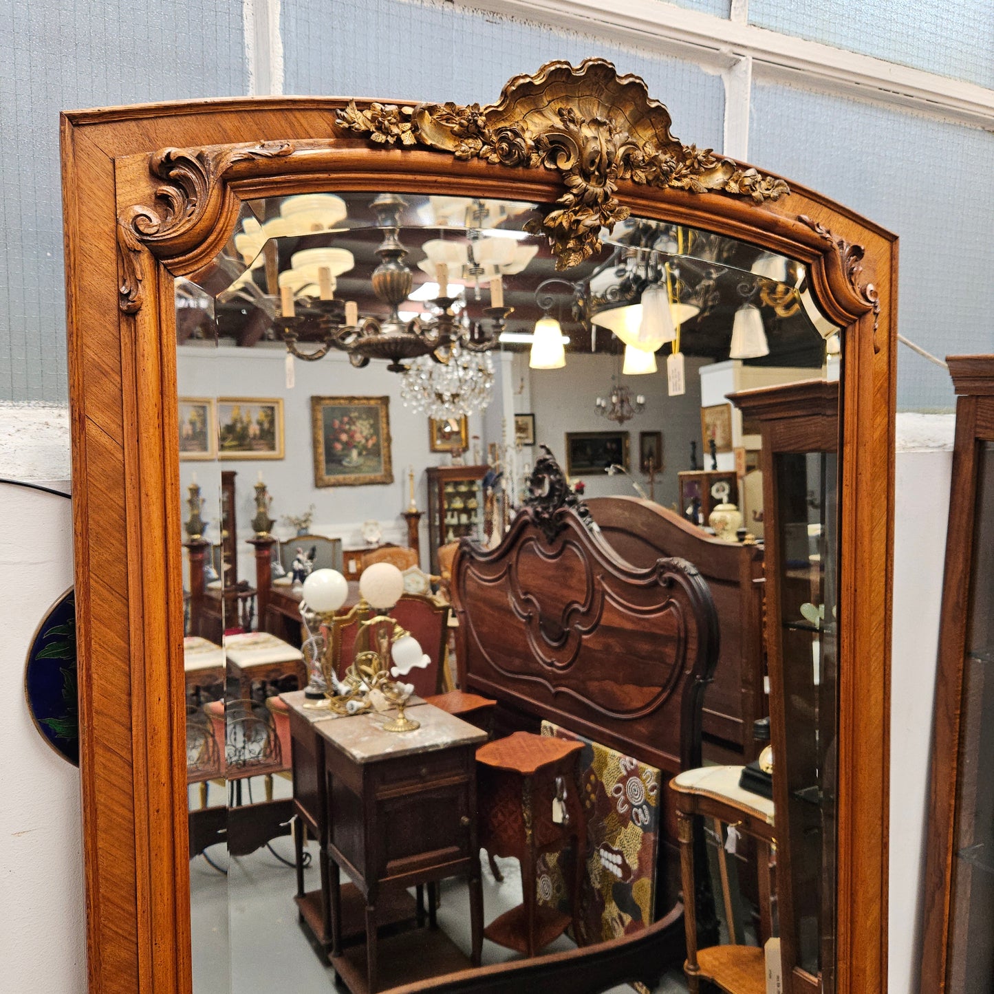 A fabulous tall Louis XV style Walnut floor/mantle mirror featuring decorative bronze gilt ormolu mounts. It still contains its beautiful original bevelled edged mirror. It has been sourced from France and is in good original detailed condition.