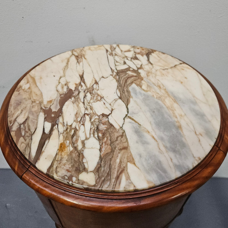 Charming Louis XVI style round side table. Features two drawers, fitted marble top and fluted legs connected by a cane shelf. Sourced directly from France and is in good original detailed condition.