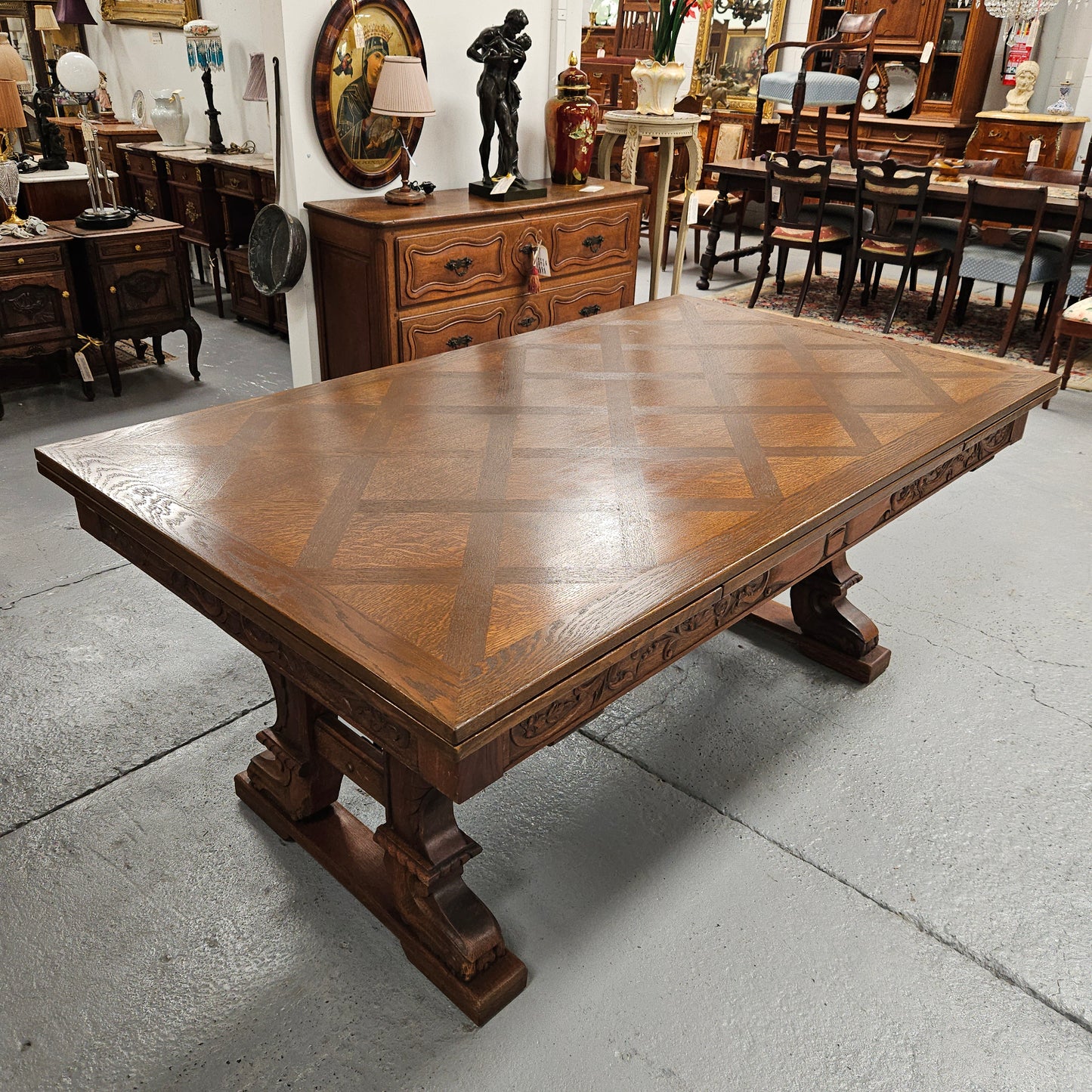 Beautiful French Oak Spanish style extension dining table with a decorative iron base and parquetry top. Lovely carvings on the legs and the skirt of the base. With the extensions closed it is 179.5 cm long and when fully extended it is 279 cm long.