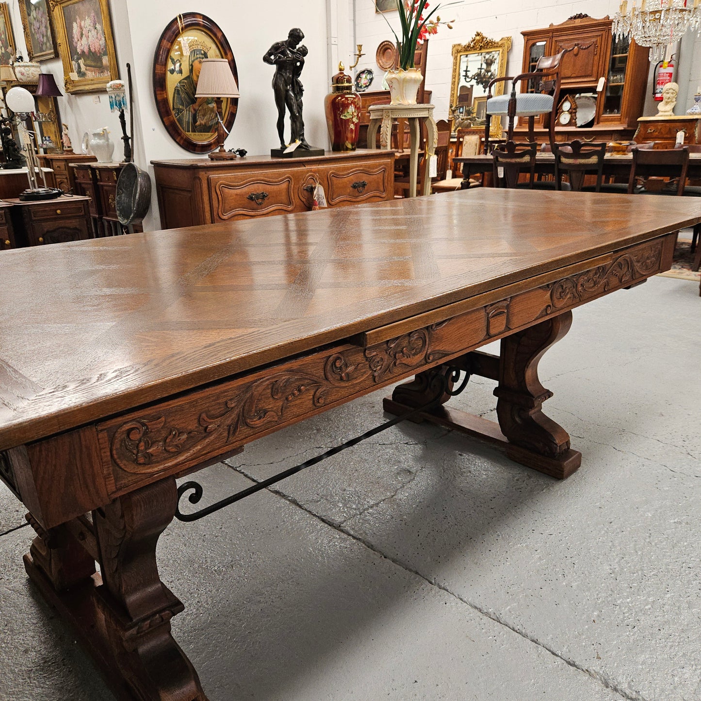 Beautiful French Oak Spanish style extension dining table with a decorative iron base and parquetry top. Lovely carvings on the legs and the skirt of the base. With the extensions closed it is 179.5 cm long and when fully extended it is 279 cm long.