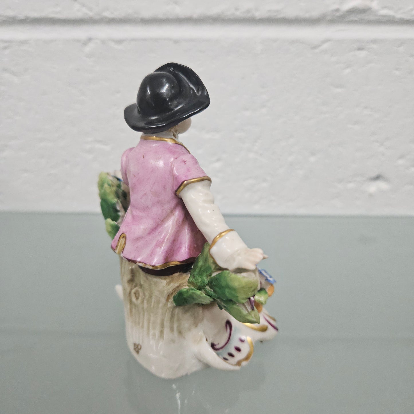 Stunning detailed early figure of a boy with flowers, there is a gold anchor mark to the back of the statue. It is in good original condition with some missing parts on the flowers as