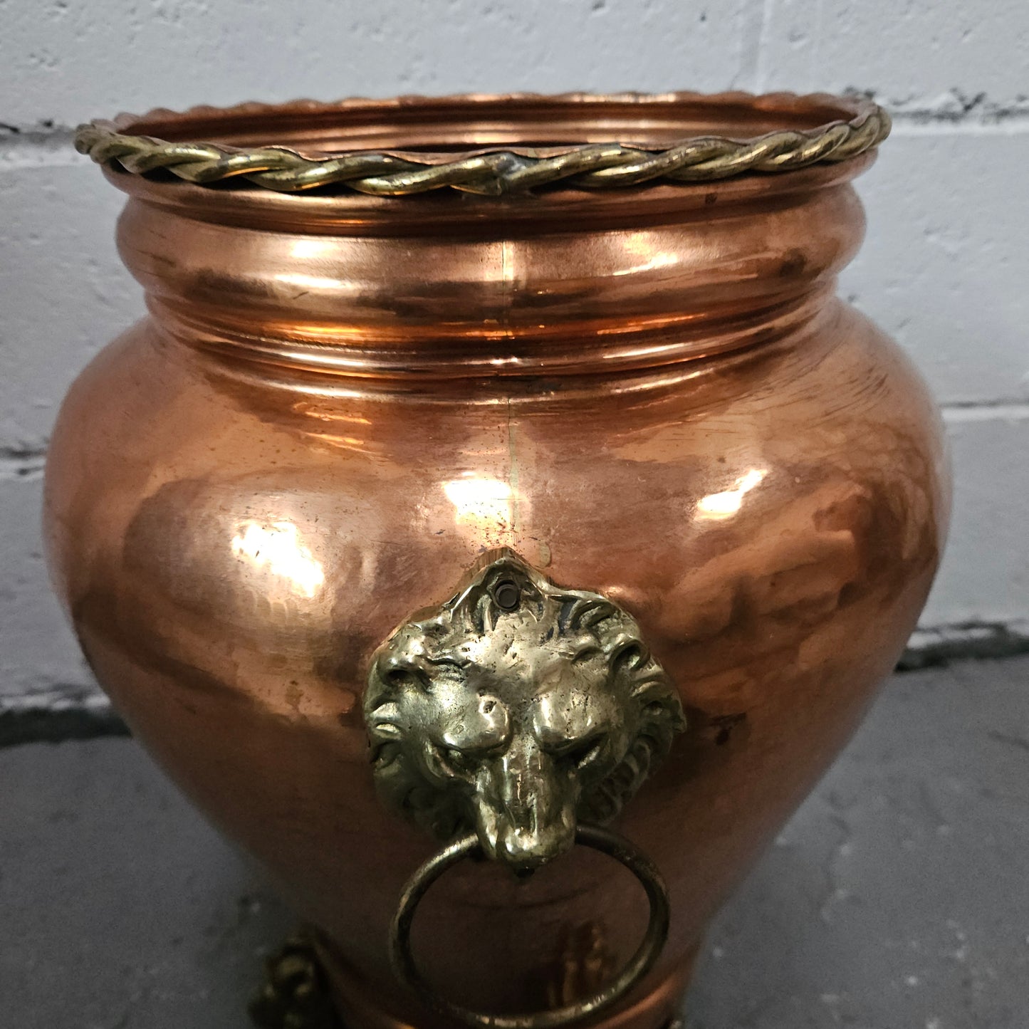 Lovely copper and brass pot with lions heads on the handles and lions feet on the base. It is in good original condition.