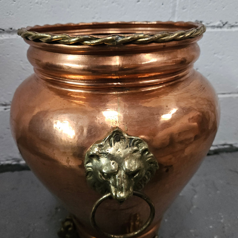 Lovely copper and brass pot with lions heads on the handles and lions feet on the base. It is in good original condition.