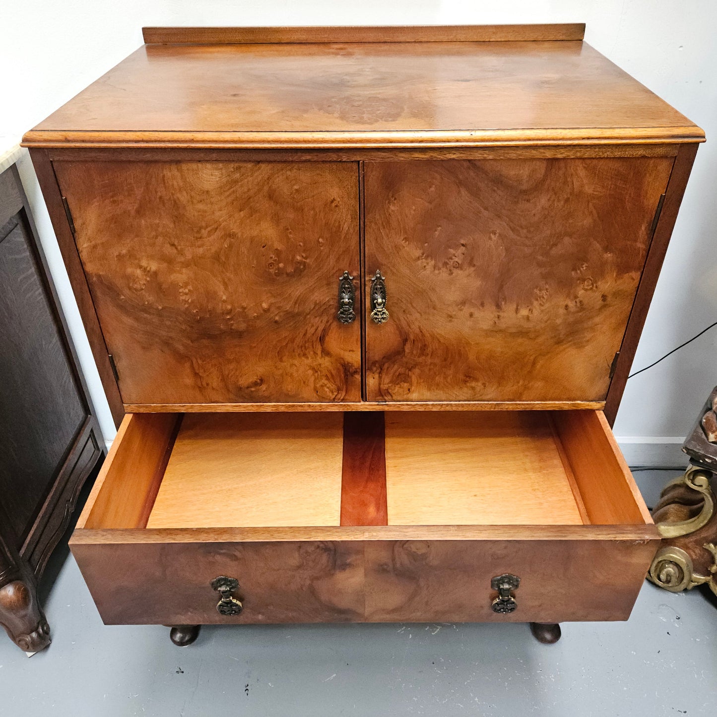 Lovely figured walnut Antique cabinet with a two door cabinet and two drawers. Circa 1930s. This cabinet can be used as a regular cabinet, drinks cabinet or tv unit as it has the hole for cables at the back. It is in good original detailed condition.