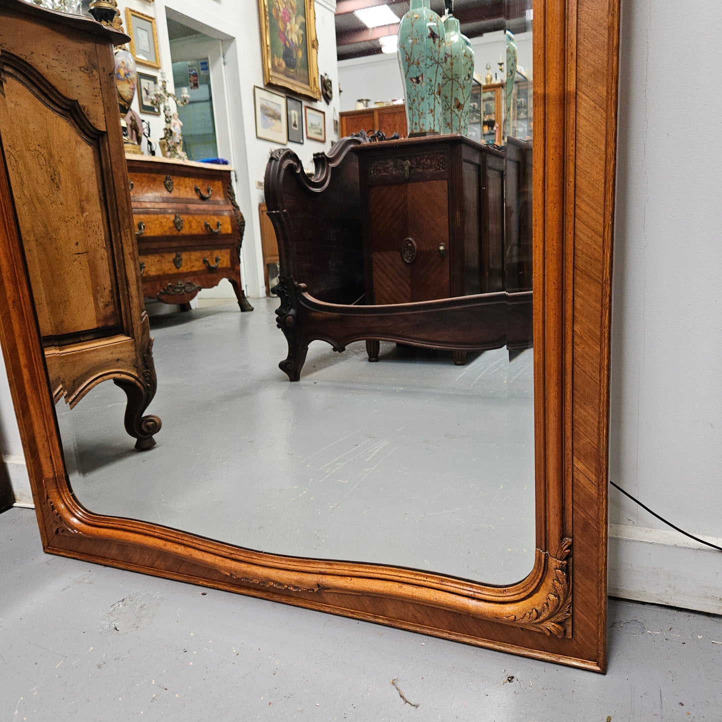 A fabulous tall Louis XV style Walnut floor/mantle mirror featuring decorative bronze gilt ormolu mounts. It still contains its beautiful original bevelled edged mirror. It has been sourced from France and is in good original detailed condition.