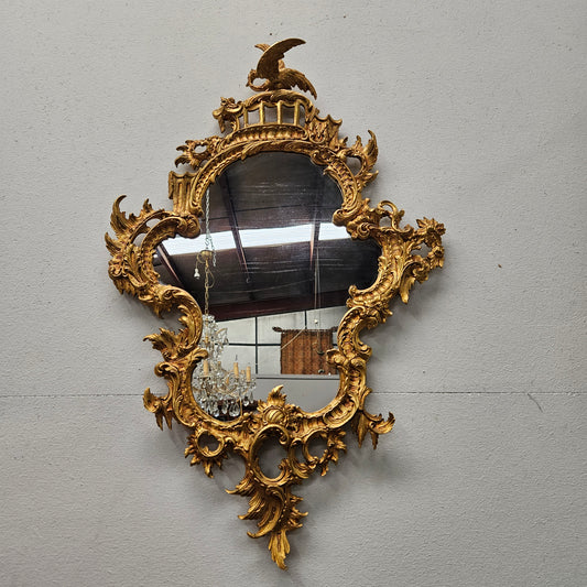 Antique French gilt bronze Louis XV style mirror featuring a bird at the top. The mirror is in good original condition but does show signs of age.