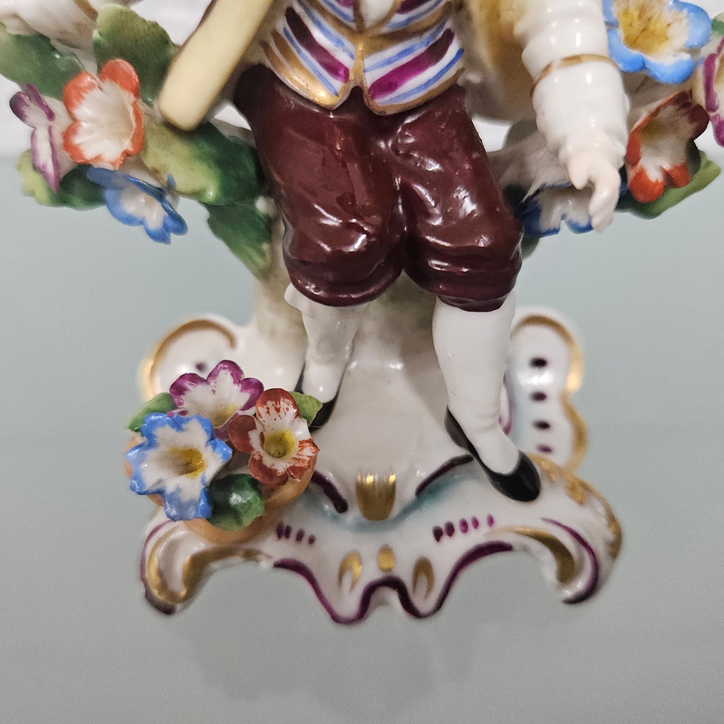 Stunning detailed early figure of a boy with flowers, there is a gold anchor mark to the back of the statue. It is in good original condition with some missing parts on the flowers as