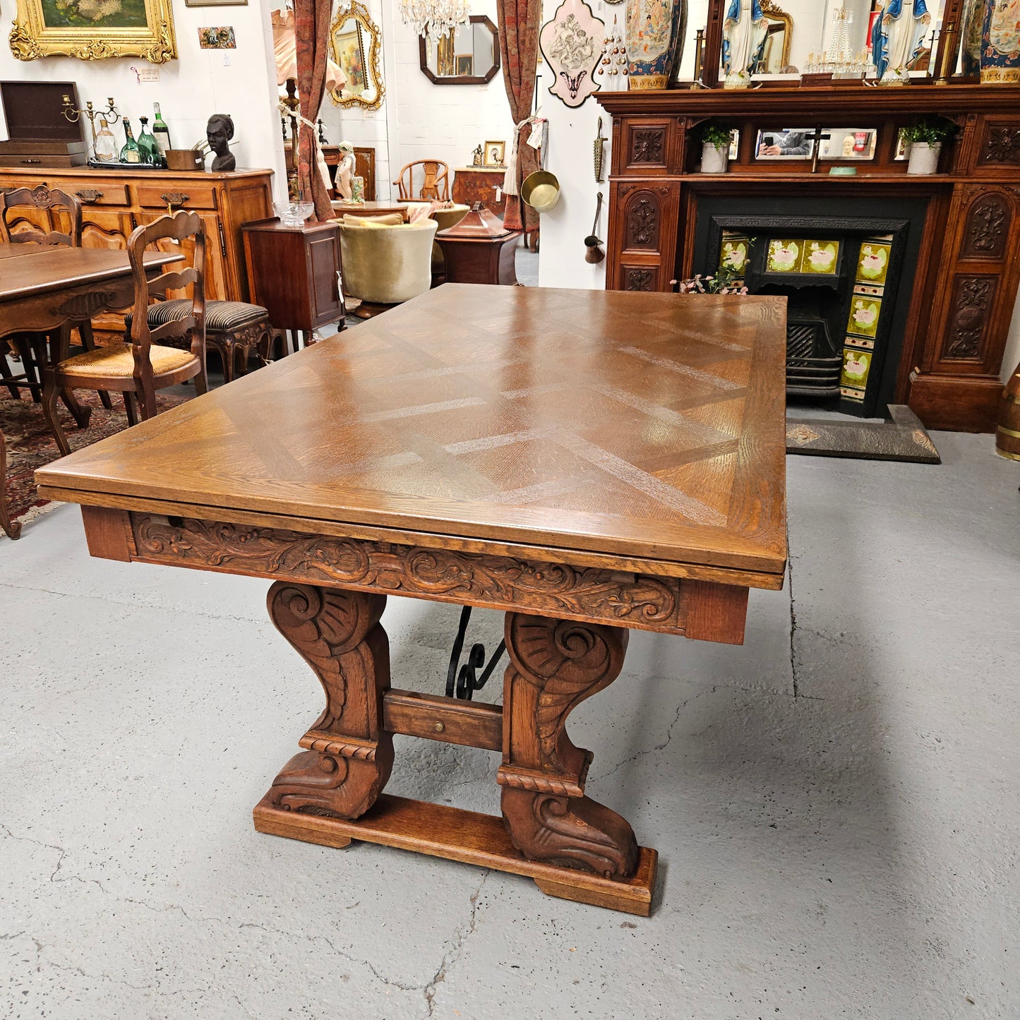 Beautiful French Oak Spanish style extension dining table with a decorative iron base and parquetry top. Lovely carvings on the legs and the skirt of the base. With the extensions closed it is 179.5 cm long and when fully extended it is 279 cm long.