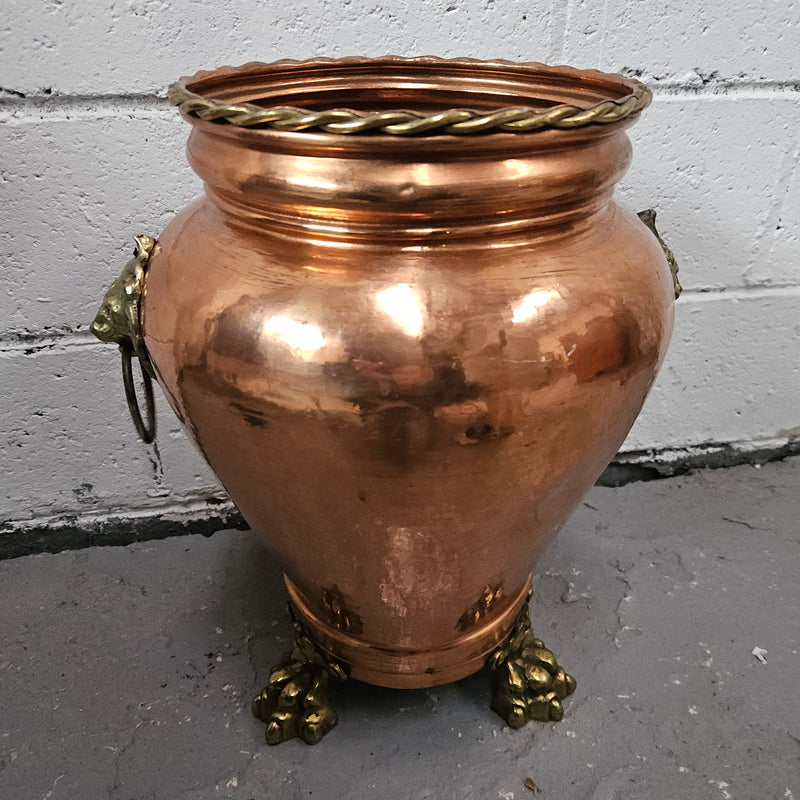 Lovely copper and brass pot with lions heads on the handles and lions feet on the base. It is in good original condition.