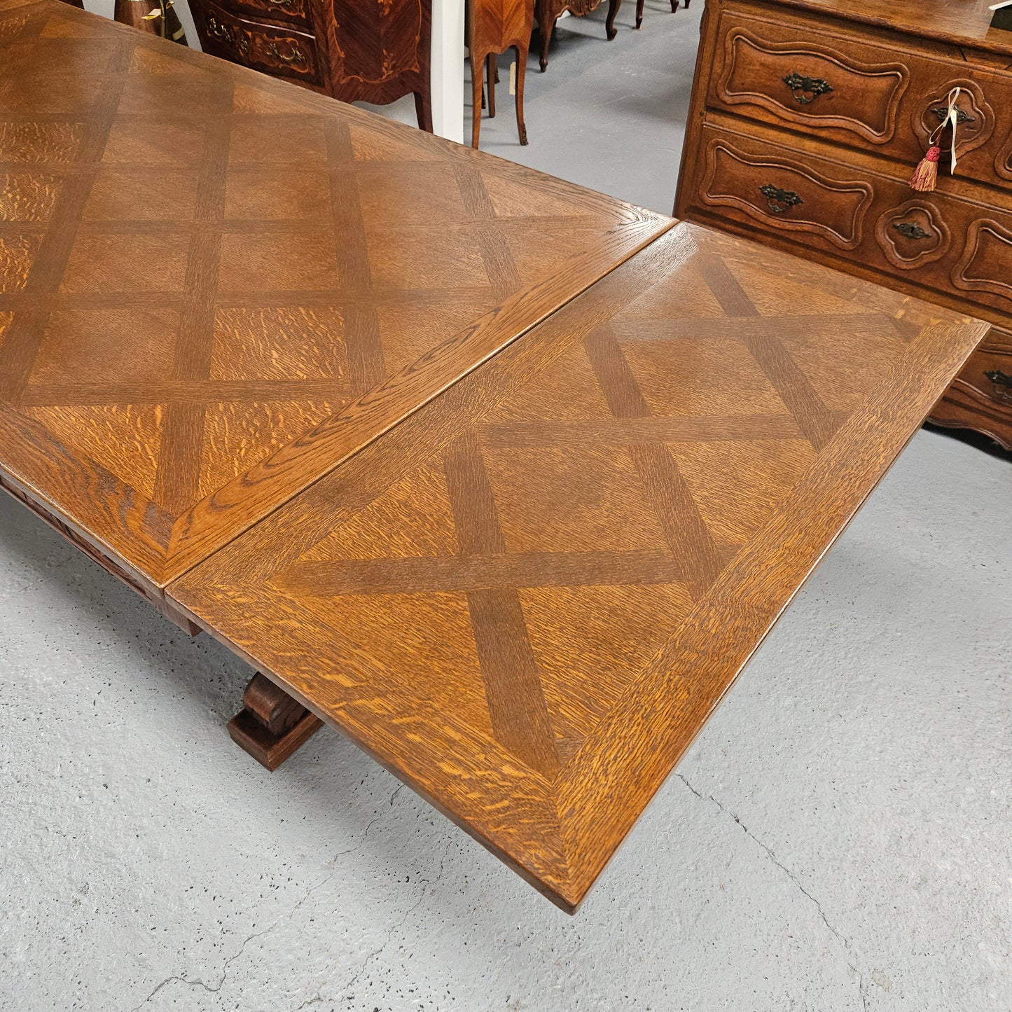 Beautiful French Oak Spanish style extension dining table with a decorative iron base and parquetry top. Lovely carvings on the legs and the skirt of the base. With the extensions closed it is 179.5 cm long and when fully extended it is 279 cm long.