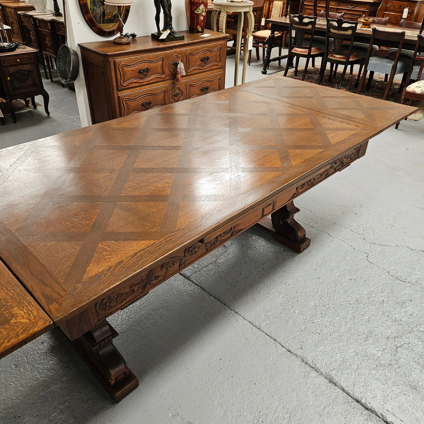 Beautiful French Oak Spanish style extension dining table with a decorative iron base and parquetry top. Lovely carvings on the legs and the skirt of the base. With the extensions closed it is 179.5 cm long and when fully extended it is 279 cm long.