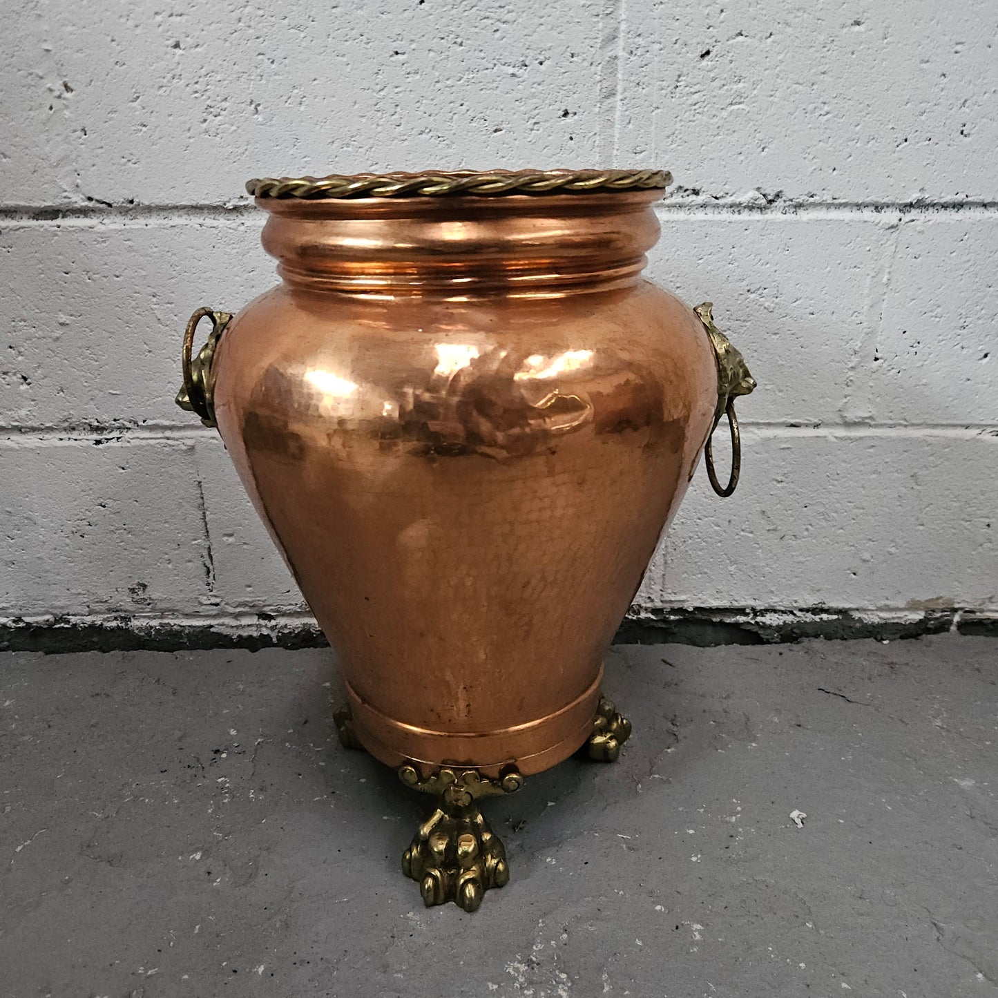 Lovely copper and brass pot with lions heads on the handles and lions feet on the base. It is in good original condition.