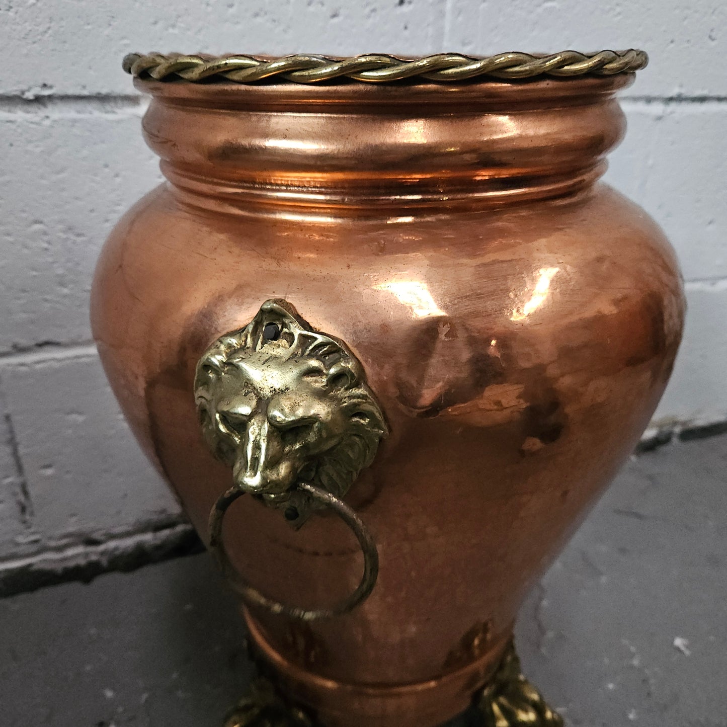 Lovely copper and brass pot with lions heads on the handles and lions feet on the base. It is in good original condition.