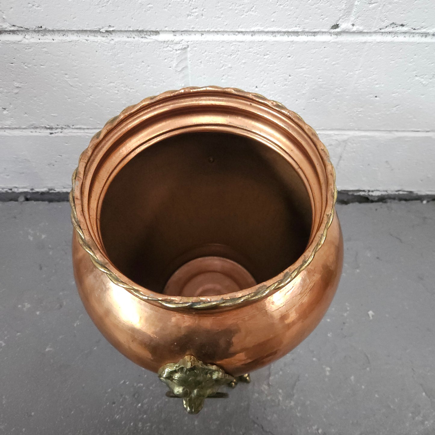 Lovely copper and brass pot with lions heads on the handles and lions feet on the base. It is in good original condition.