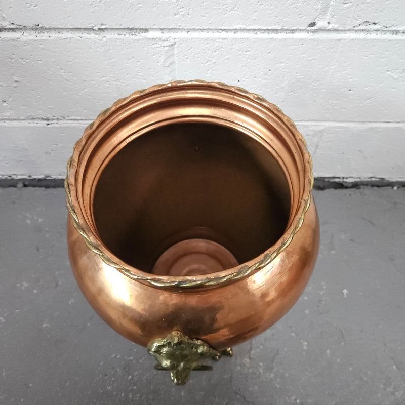 Lovely copper and brass pot with lions heads on the handles and lions feet on the base. It is in good original condition.