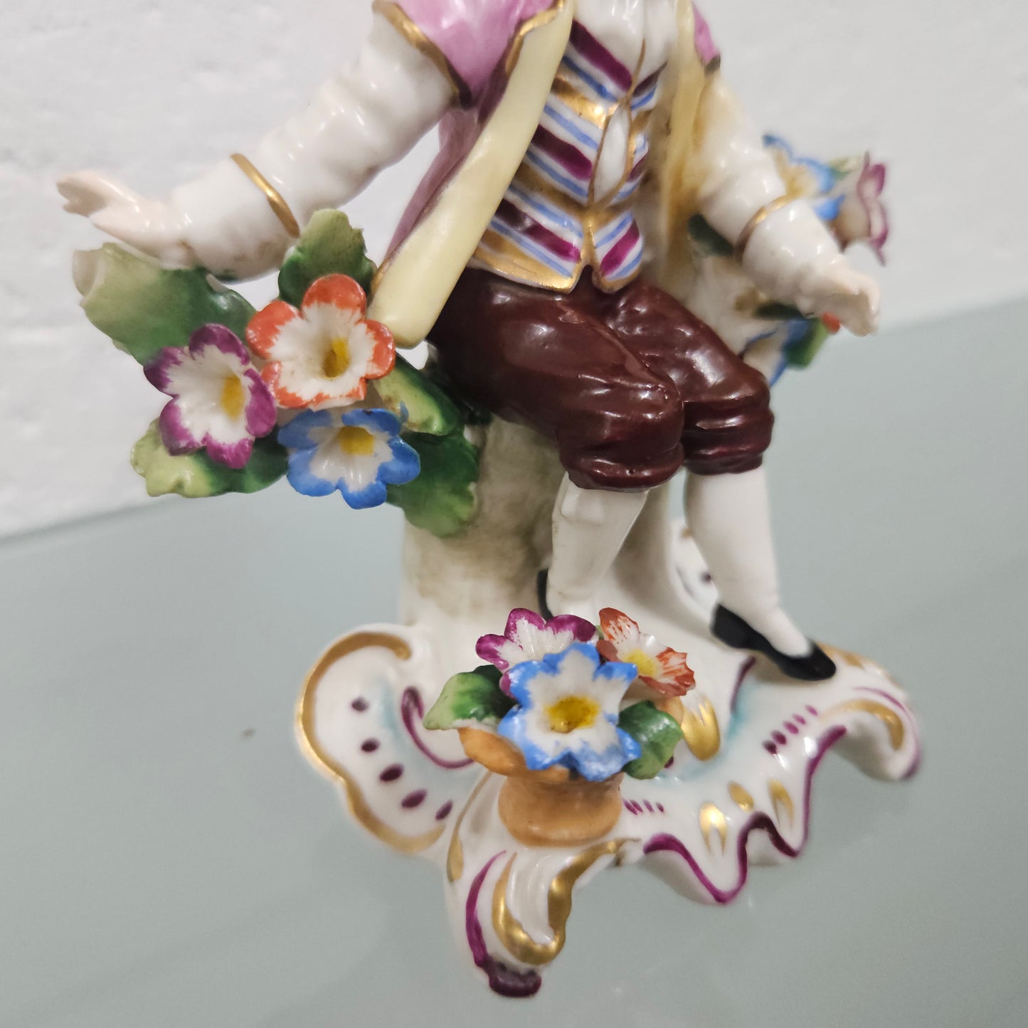Stunning detailed early figure of a boy with flowers, there is a gold anchor mark to the back of the statue. It is in good original condition with some missing parts on the flowers as