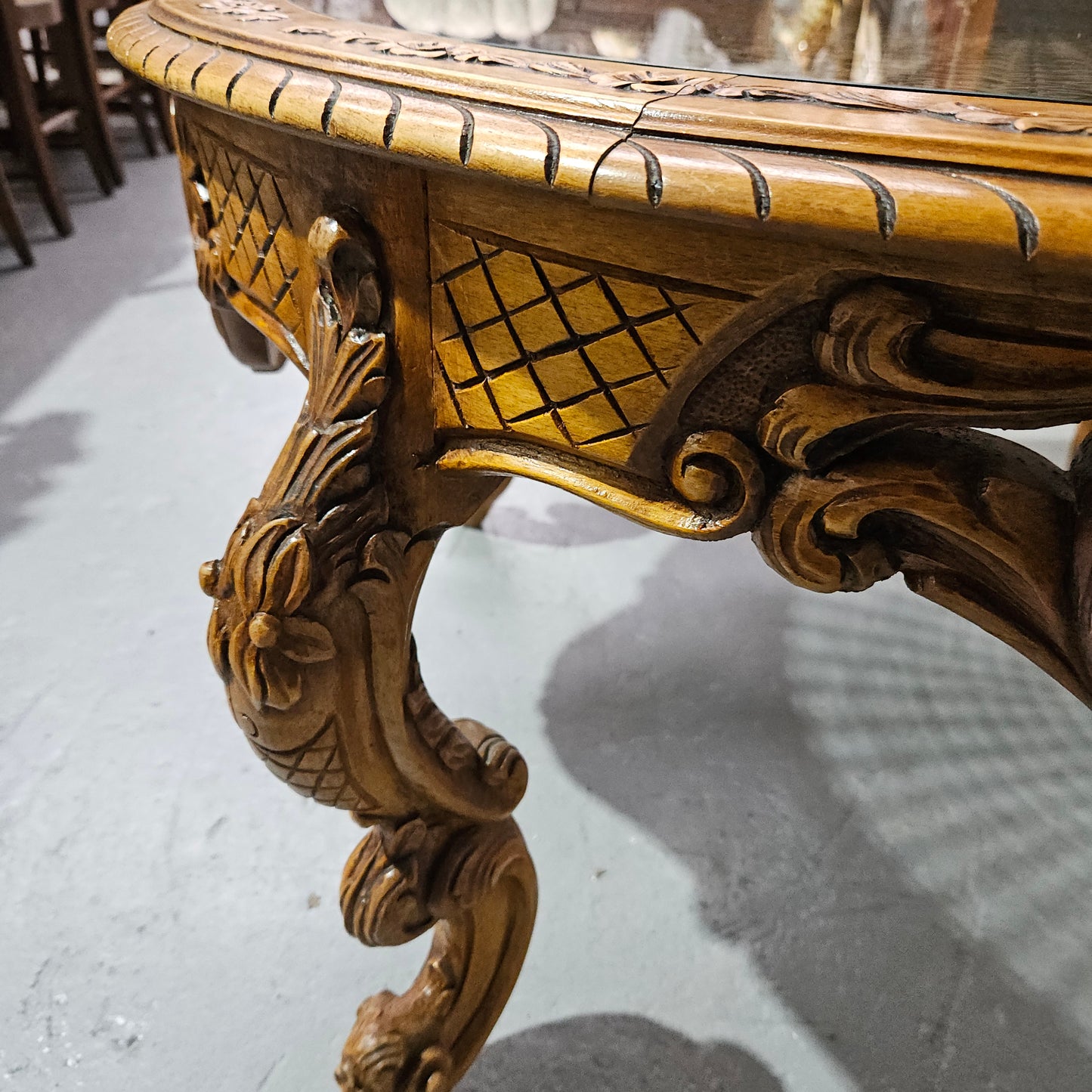 French oak Louis XV style round cane insert coffee table with highly decorative legs and table top. It has a glass cover to fit over the cane. It is in good original condition and has been sourced from France.