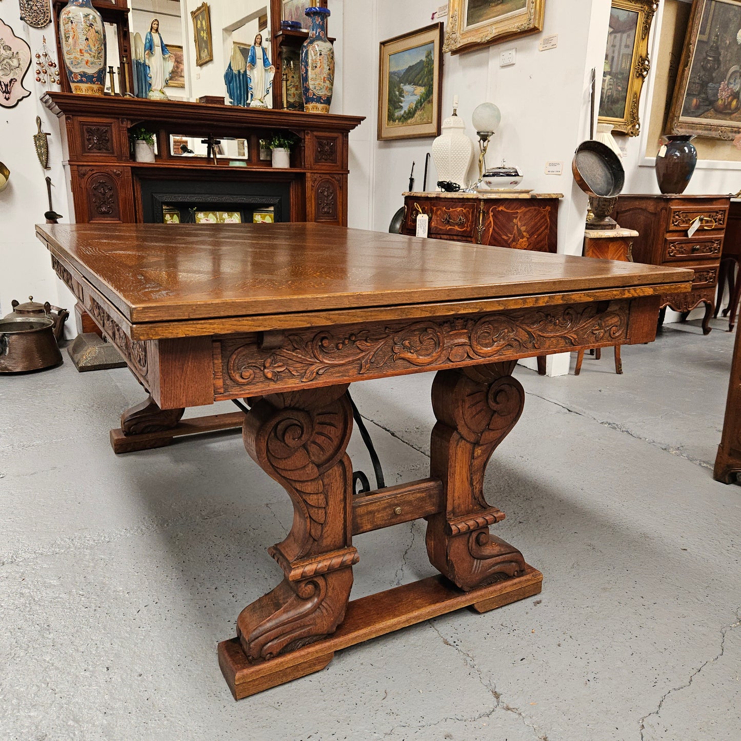 Beautiful French Oak Spanish style extension dining table with a decorative iron base and parquetry top. Lovely carvings on the legs and the skirt of the base. With the extensions closed it is 179.5 cm long and when fully extended it is 279 cm long.