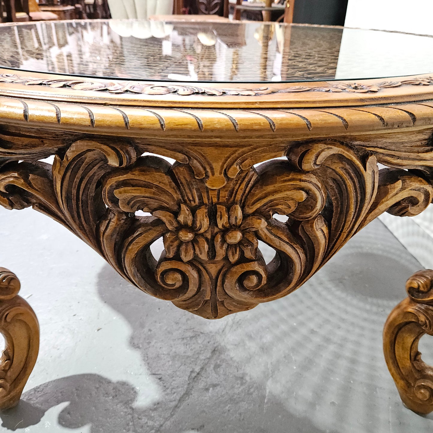 French oak Louis XV style round cane insert coffee table with highly decorative legs and table top. It has a glass cover to fit over the cane. It is in good original condition and has been sourced from France.