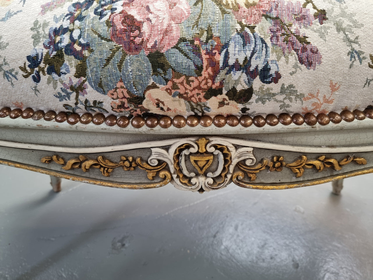 Antique painted Louis XV style upholstered stool. It has lovely floral upholstery that is in good condition with no tears. It is in good original detailed condition.
