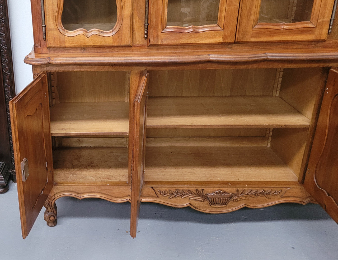 Magnificent French Walnut two-body four door display cabinet. Heaps of storage space with four glass doors at the top with shelves and four solid doors below also with shelving. It has been sourced from France and comes with a key for each door and all are lockable. In good original detailed condition.