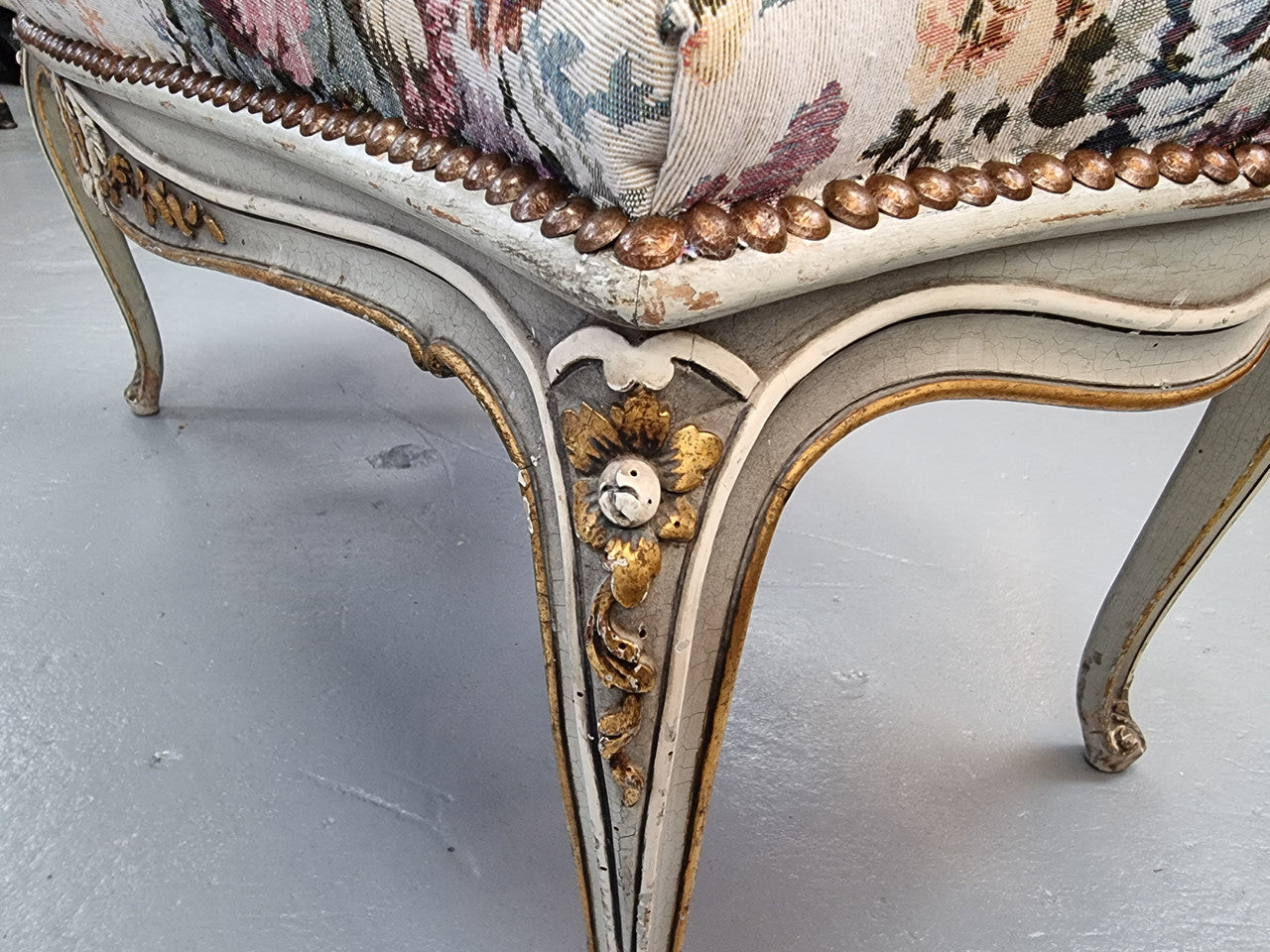 Antique painted Louis XV style upholstered stool. It has lovely floral upholstery that is in good condition with no tears. It is in good original detailed condition.
