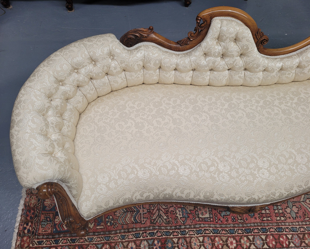 Upholstered Victorian walnut double ended chaise lounge with nice decorative carving. It has original castors and in very good condition. The upholstery is in "like new condition".