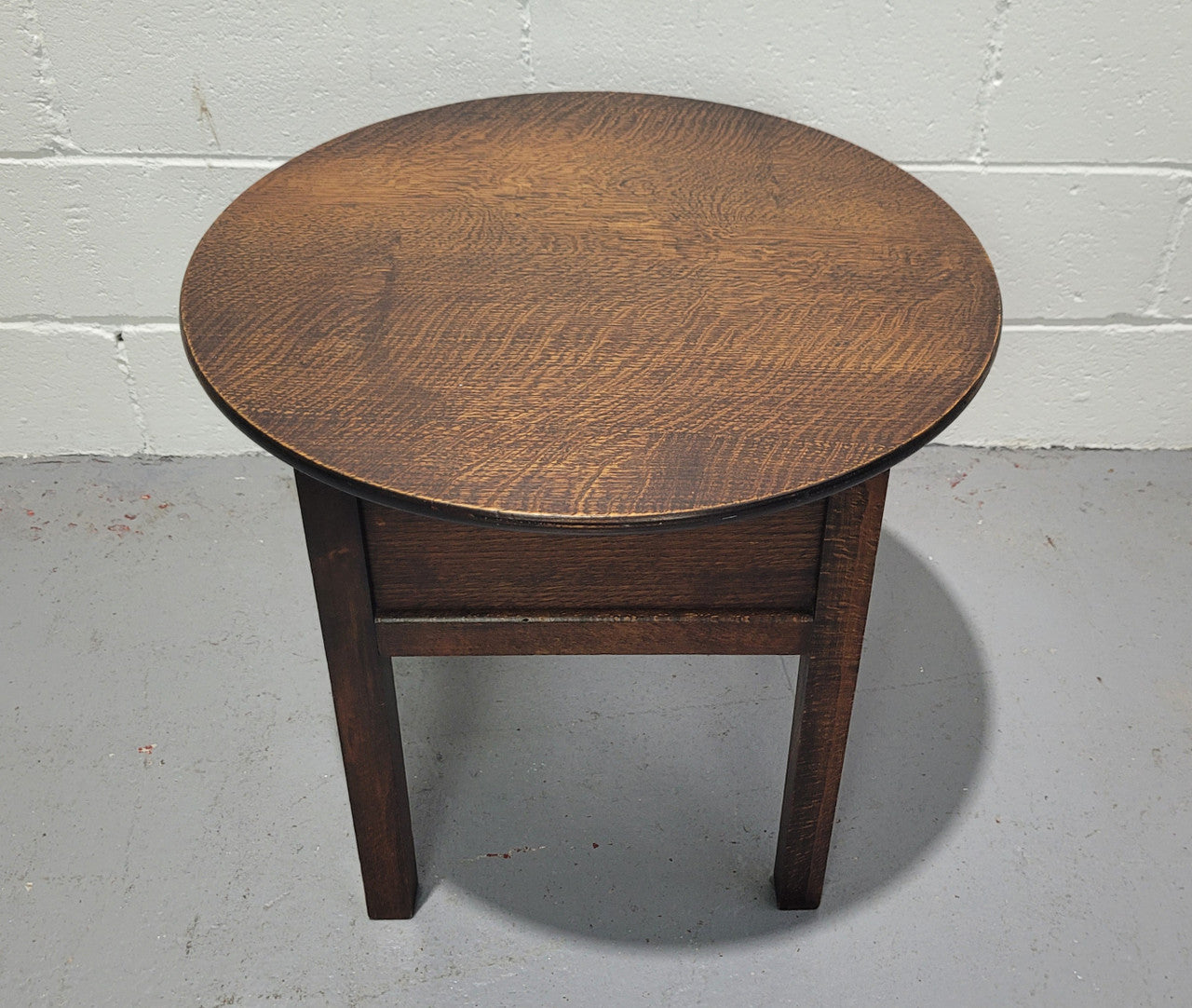 Fabulous round oak side table which also has a hidden sewing box underneath with lovely original blue satin lining and Includes pictured sewing items. It is in good original condition.