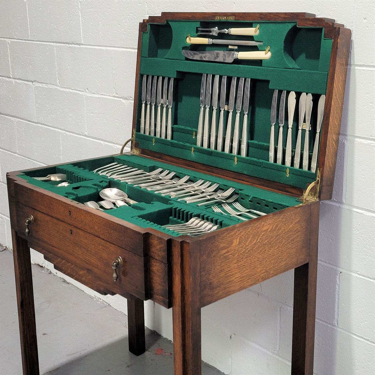 English Oak beautifully fitted cutlery table with a lift up top and drawer. Contains extensive silver plate part cutlery service by Elkington. In good original condition.