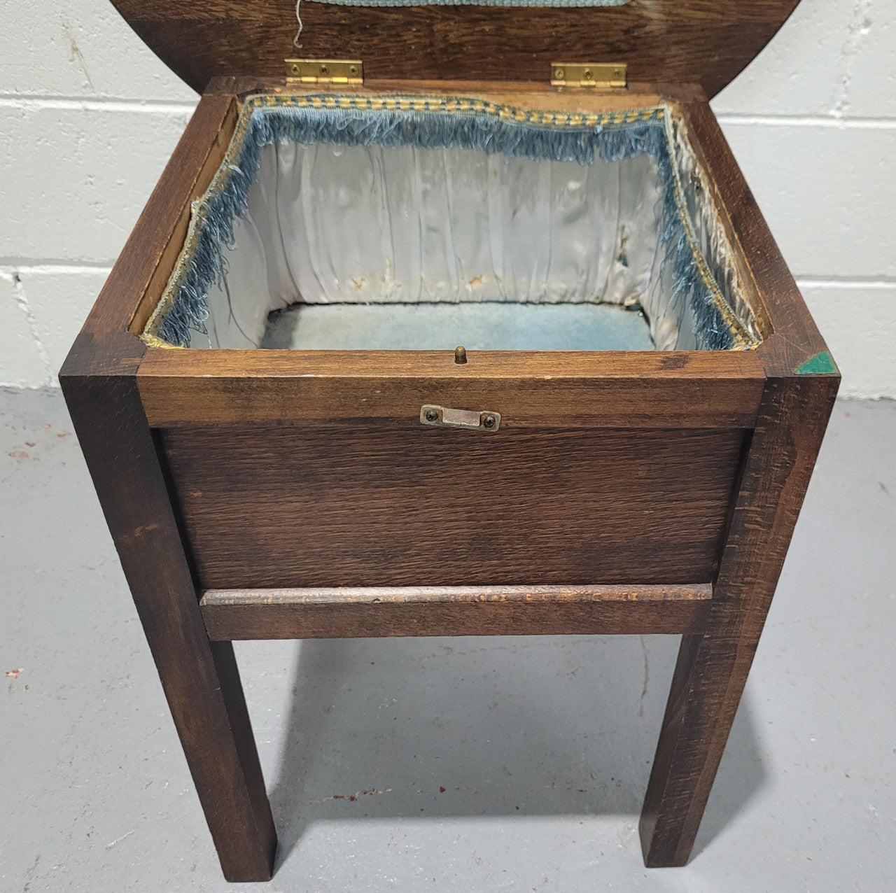 Fabulous round oak side table which also has a hidden sewing box underneath with lovely original blue satin lining and Includes pictured sewing items. It is in good original condition.