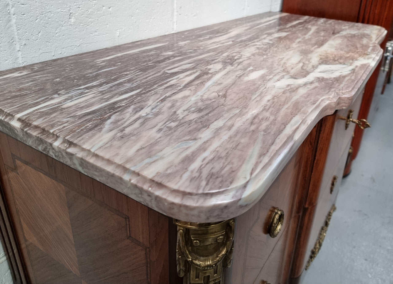 A stunning French transitional Louis XV and Louis XVI style commode. It has beautiful walnut inlay and a fabulous marble top. Comes with two drawers and fitted with gilt brass mounts. it is In very good original condition.