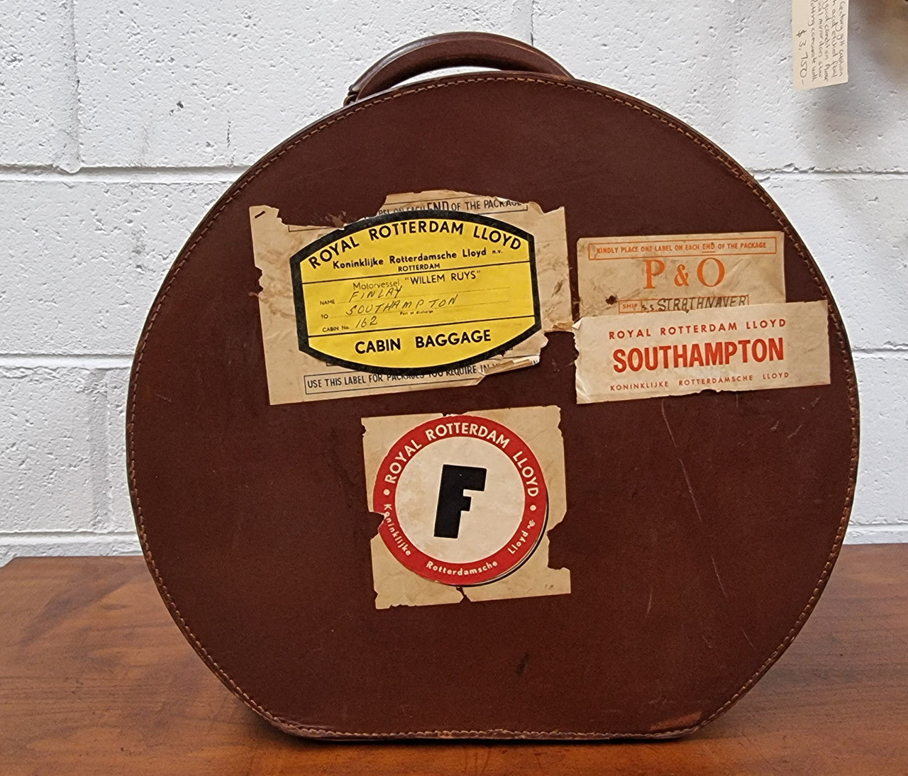 Charming solid leather hatbox with patterned fabric interior and two interior pockets. Interior stamp is for The Mutual Store Melbourne. Bears paper stamps for P&O Cruise Passenger” & “Peninsular the top and D.M.F. in gold near the handle. Circa: Early 1900’s. 43 cm across and H:21 cm the lid.