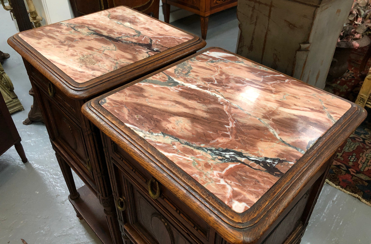 Lovely pair of French Oak Louis XVI style bedside cabinets with inset marble tops a drawer and a cupboard for storage. In good original detailed condition.