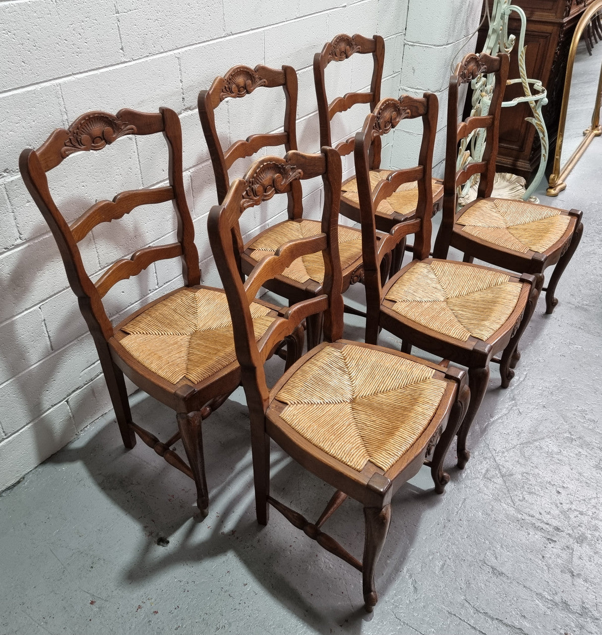 Lovely set of six French oak rush seated provincial dining chairs. They have been sourced from France and are in good detailed condition.