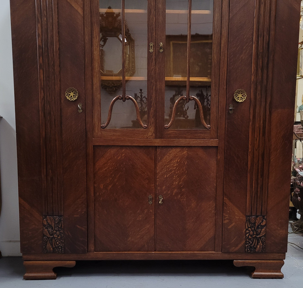 Stylish French Art Deco Oak bookcase with heaps of storage space and shelves. Middle section has two glass display doors. In good original detailed condition.