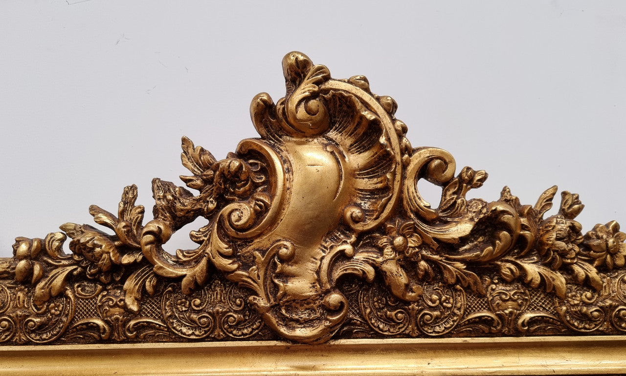 French ornate gilt decorated and floral bevelled mirror. It has been sourced from France and it is in good original condition.