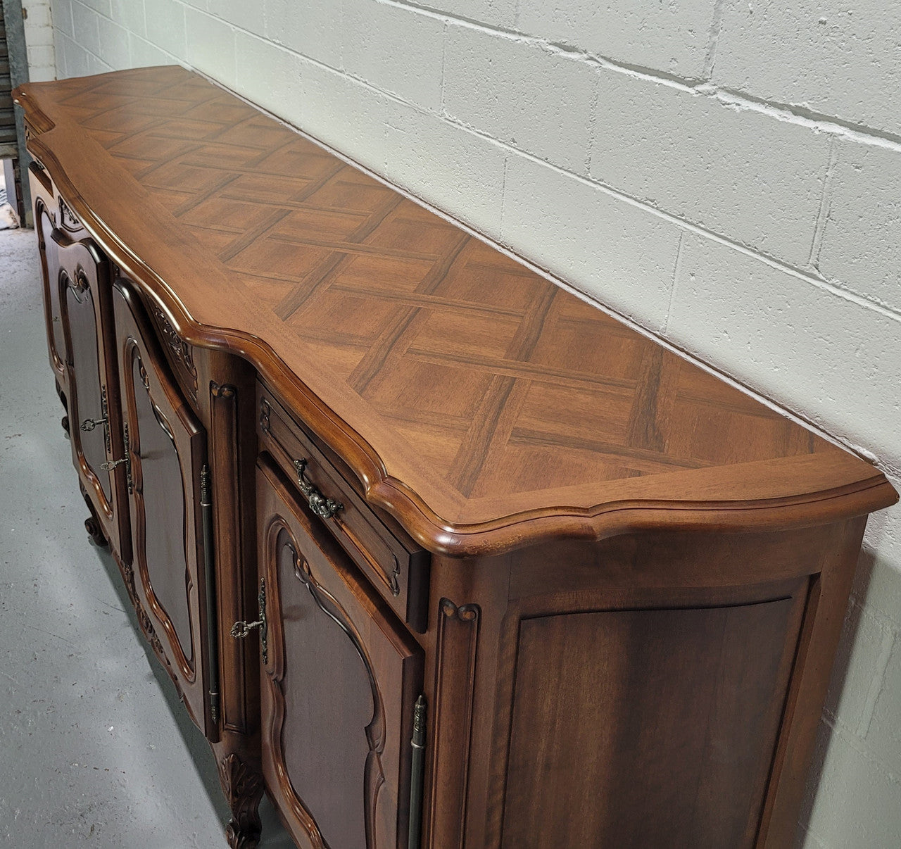 Walnut Louis XV style parquetry top four door sideboard with beautiful carving. Plenty of storage space and it is in good original detailed condition.