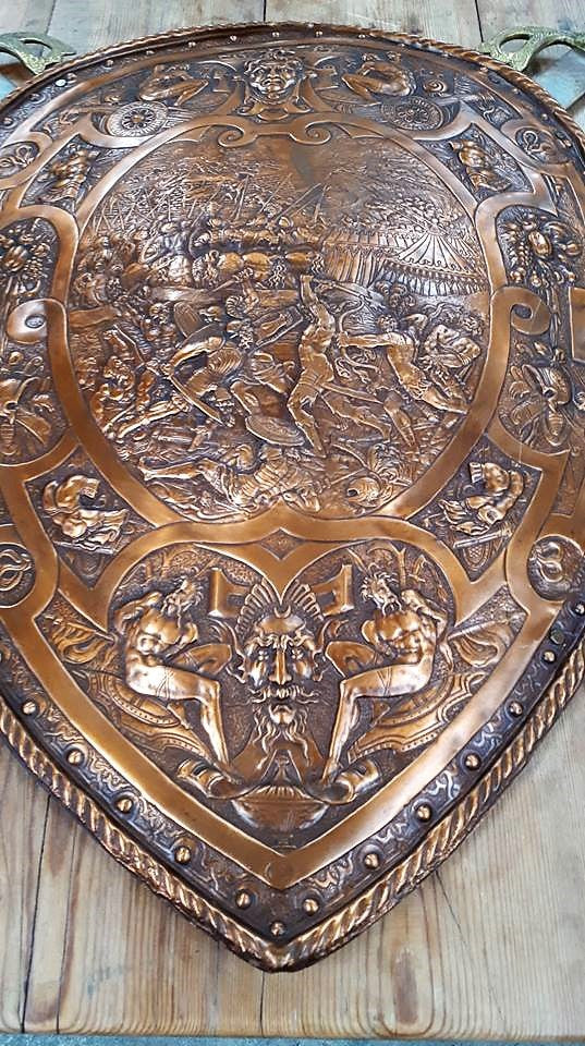 A beautiful European Antique very detailed embossed copper Shield with Swords. Look closely to see the amazing detail in the shield of a fighting scene. It has brass handles on the steel swords. It is In amazing original condition.