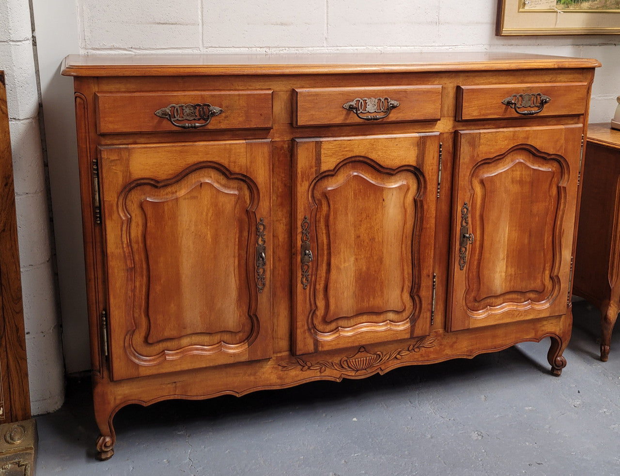 Beautiful French three door three drawer Louis XV style Cherrywood sideboard. It has a total of four adjustable shelves and comes with three keys. It has been sourced from France and is in good original detailed condition.
