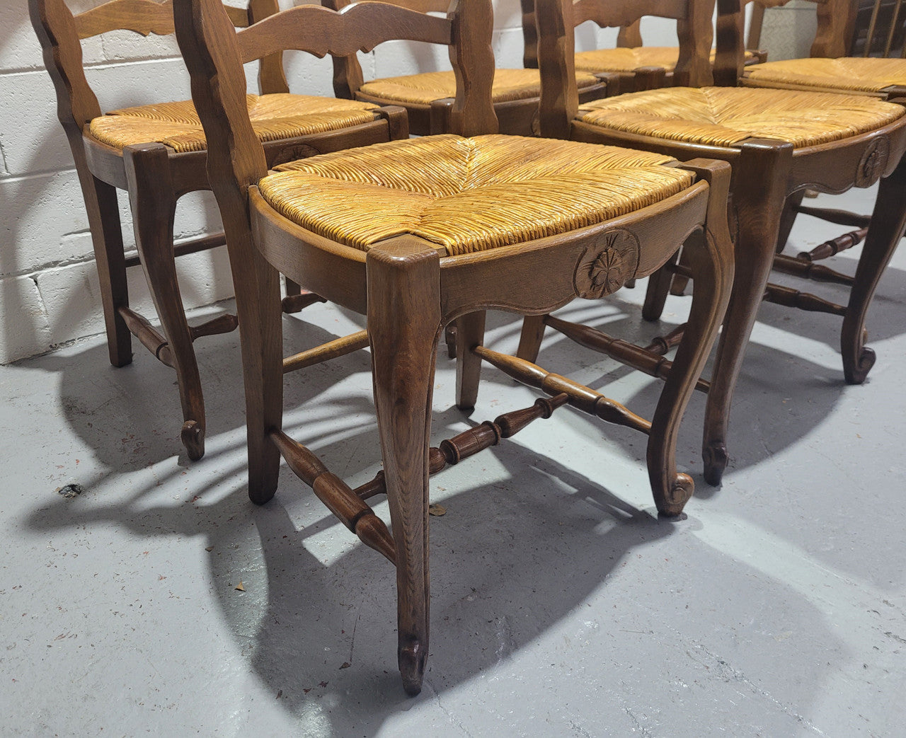Set of six French Louis 15th style rush seated dining chairs. They are comfortable to sit in and are in original condition.