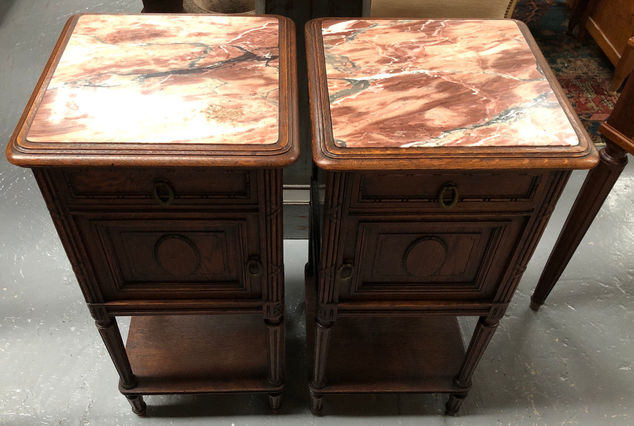 Lovely pair of French Oak Louis XVI style bedside cabinets with inset marble tops a drawer and a cupboard for storage. In good original detailed condition.