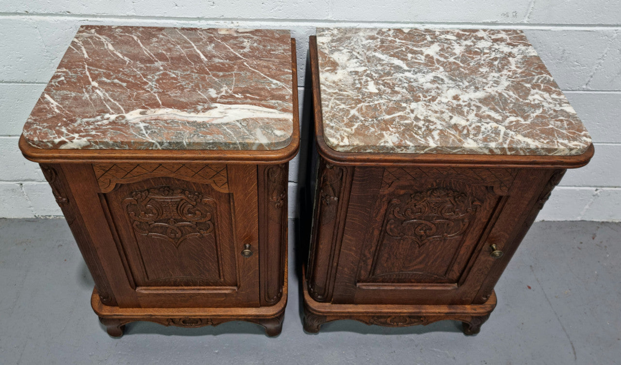 Lovely pair of French oak bedside cabinets with nicely carved details and marble tops. In good original detailed condition.